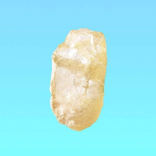 Rough translucent yellow crystal against light blue background
