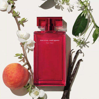 Red Narciso Rodriguez perfume bottle with peach, vanilla bean, and flowers on a light background