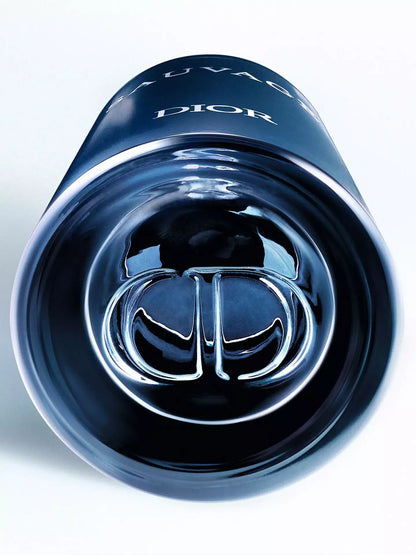 Close-up of a glossy dark blue Dior Sauvage bottle showing the embossed silver-toned Dior logo and part of the white DIOR and SAUVAGE text on a clean white background.