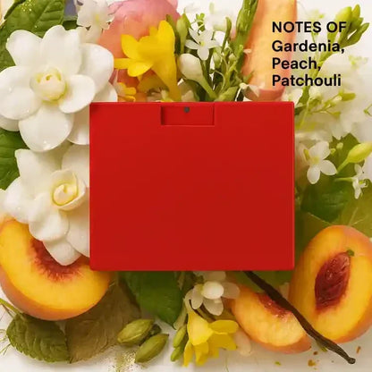 Red perfume box surrounded by gardenia, peach, and patchouli notes