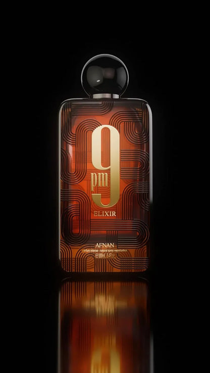 A rectangular Apinan 9pm Elixir perfume bottle with a black spherical cap, featuring a dark amber-brown body with gold circuit-like patterns and a large gold '9' logo, set against a solid black background with a reflection below.