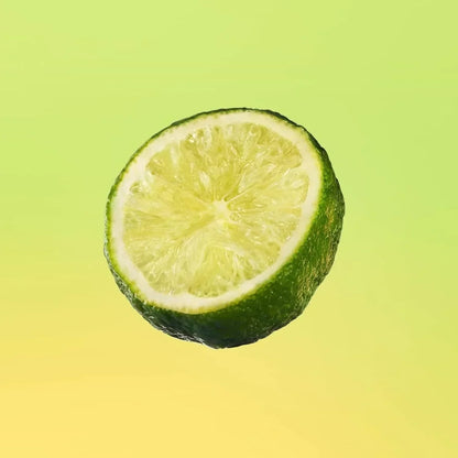 Half lime slice with vibrant green rind against gradient yellow background