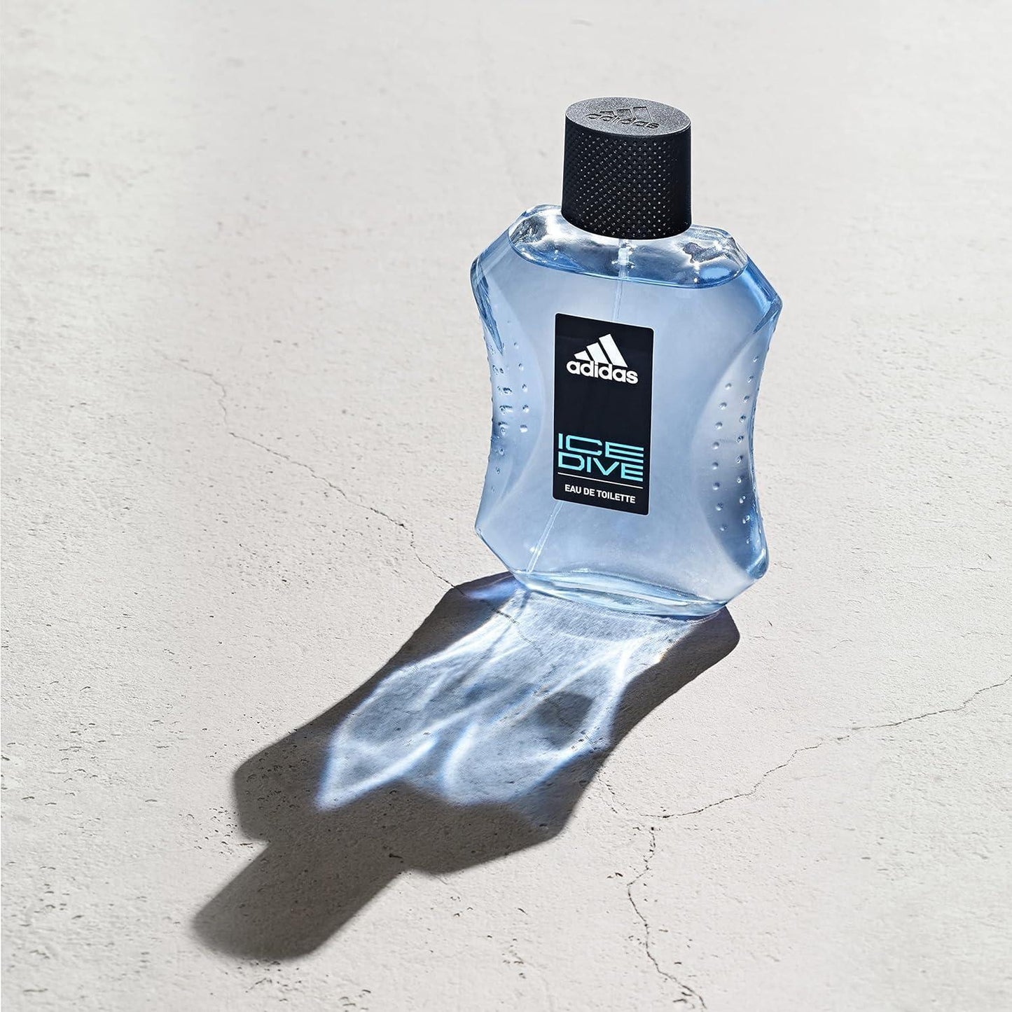 Adidas Ice Dive Eau de Toilette fragrance bottle on textured surface