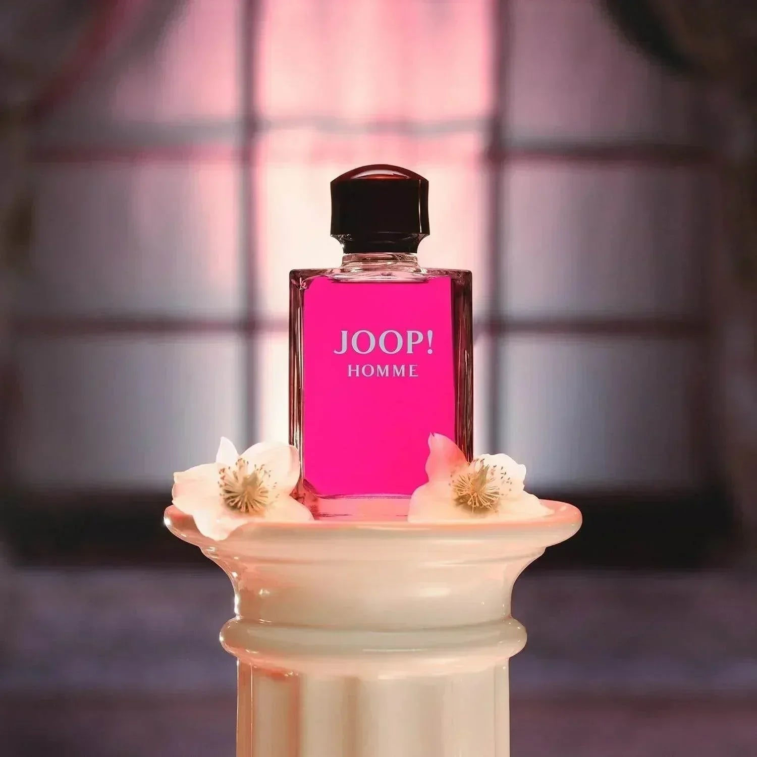JOOP! Homme Eau de Toilette fragrance bottle on pedestal with flowers