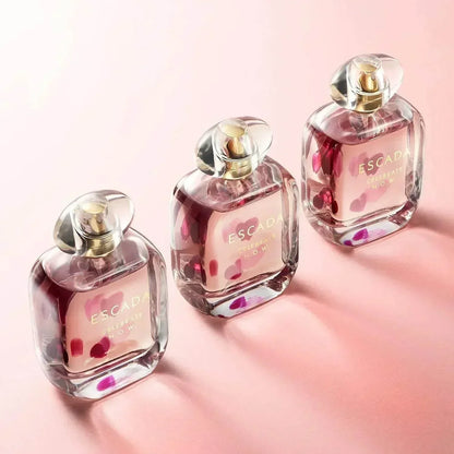 Escada Celebrate N.O.W. Eau de Parfum bottles with pink floral design on soft pink background