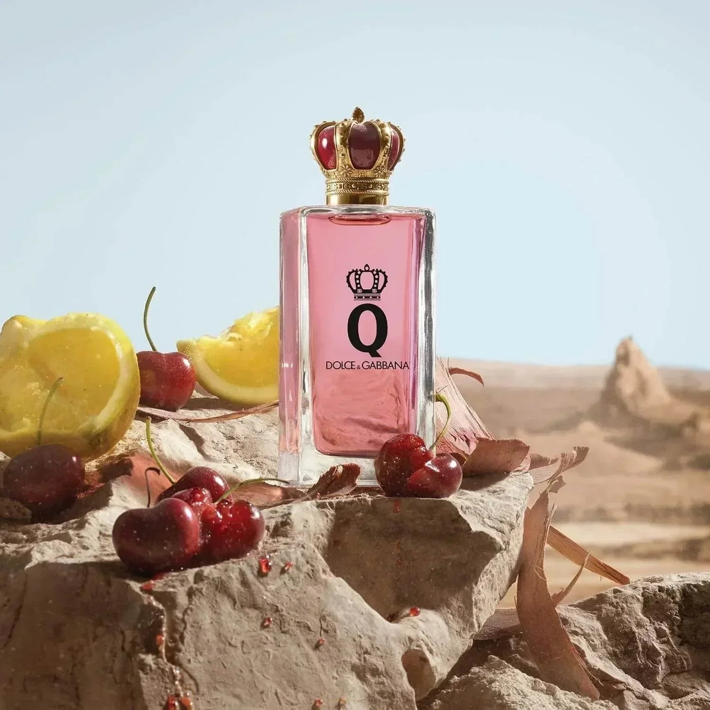 Dolce & Gabbana Q Eau de Parfum bottle with cherries and lemon on rock