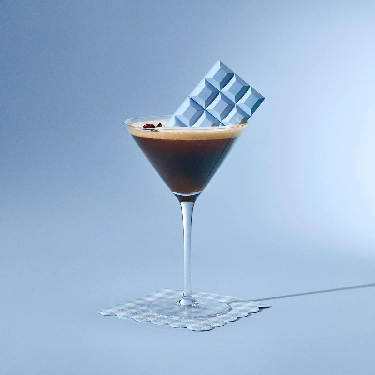 Cocktail with a chocolate cube on a blue background