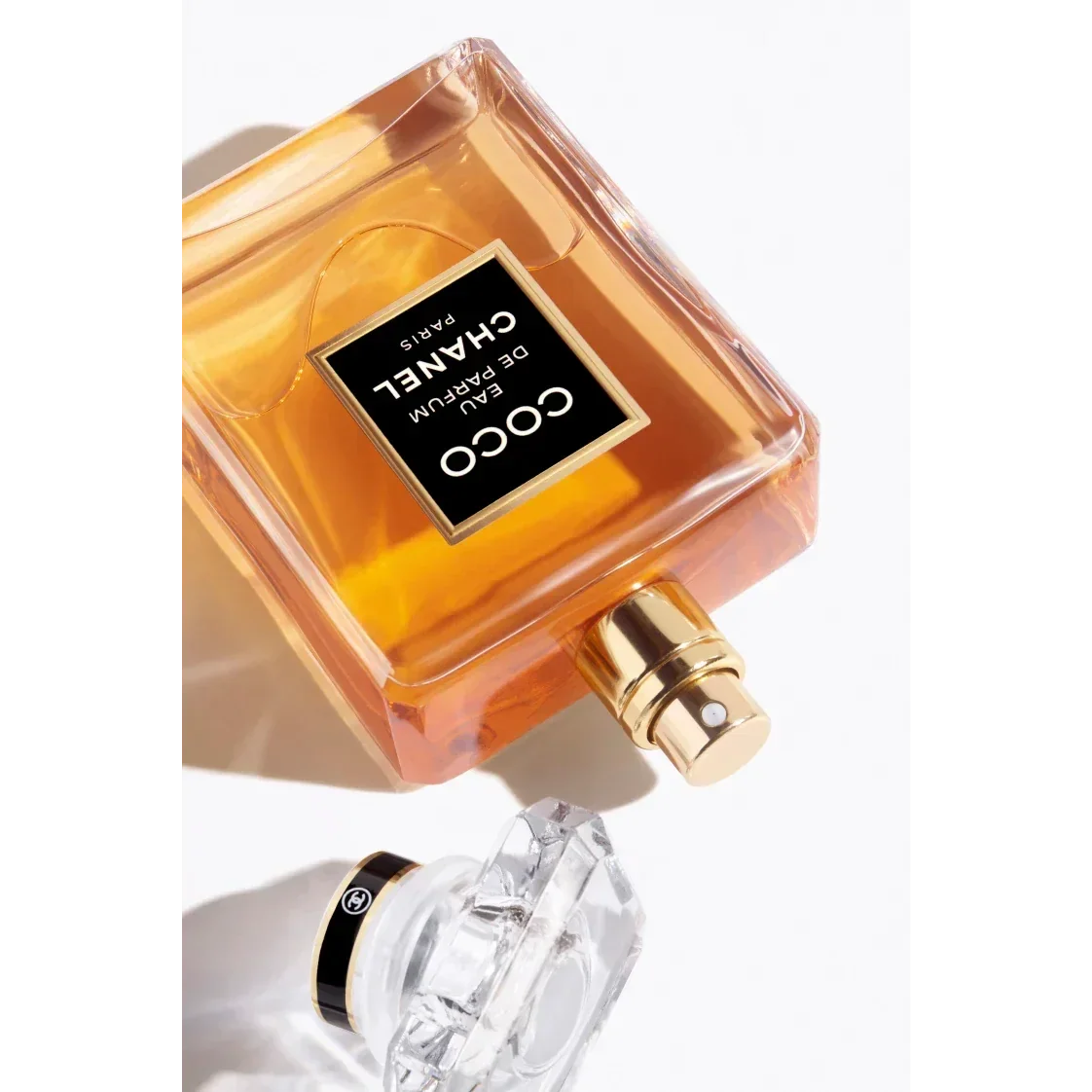 Coco Chanel Eau de Parfum spray bottle with gold cap on white background