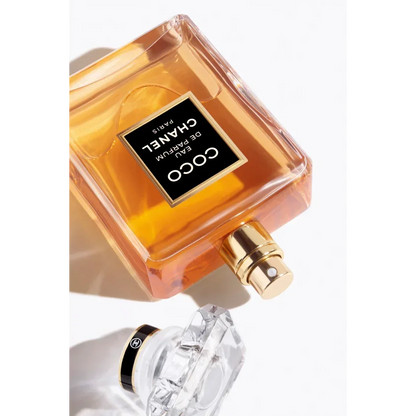Coco Chanel Eau de Parfum spray bottle with gold cap on white background