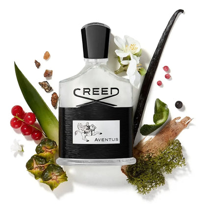 Creed Aventus perfume bottle surrounded by flowers, leaves, and fruits on a white background