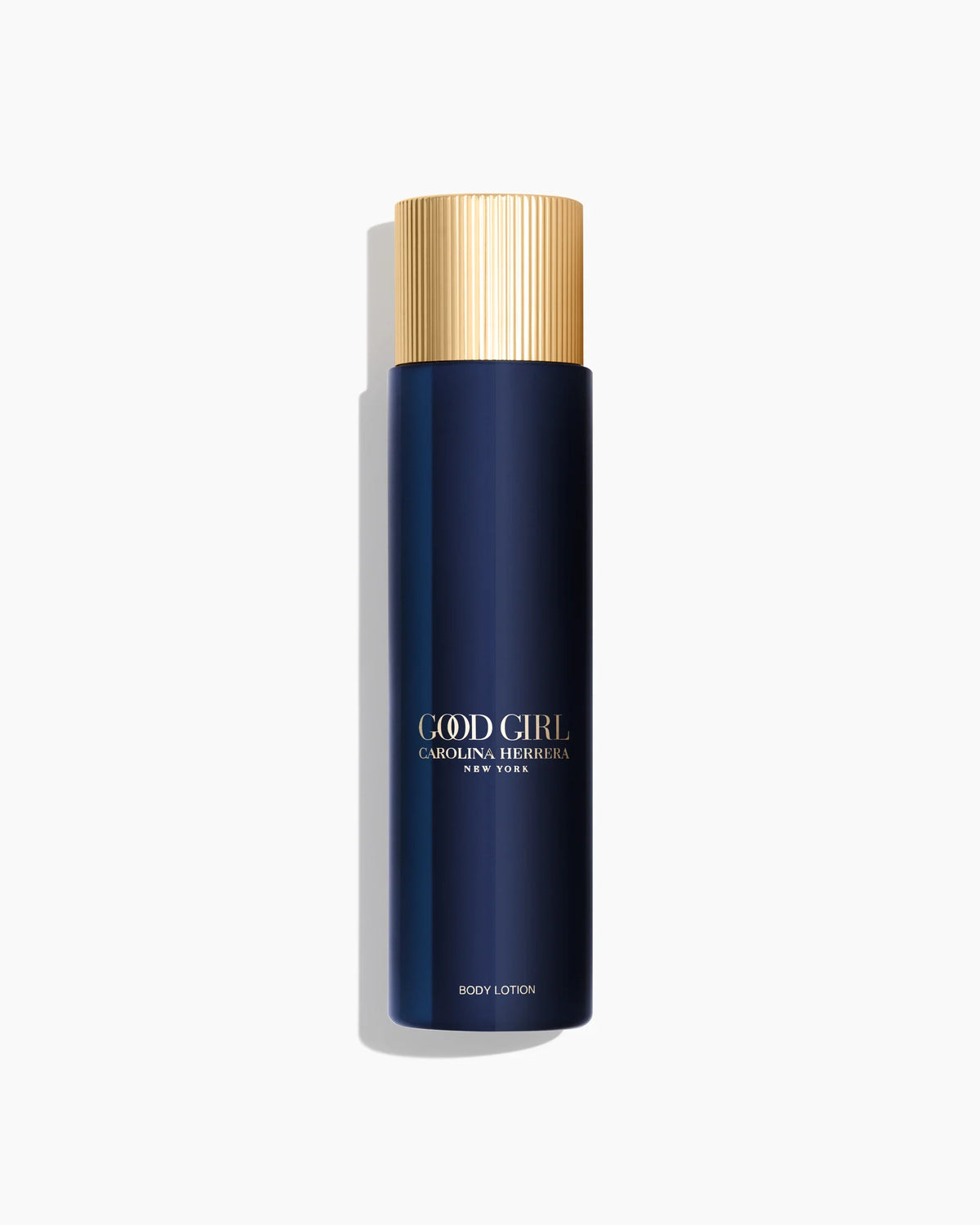 A tall cylindrical body lotion bottle by Carolina Herrera, featuring a deep navy blue body and a ribbed metallic gold cap, set against a clean white background with a soft shadow.